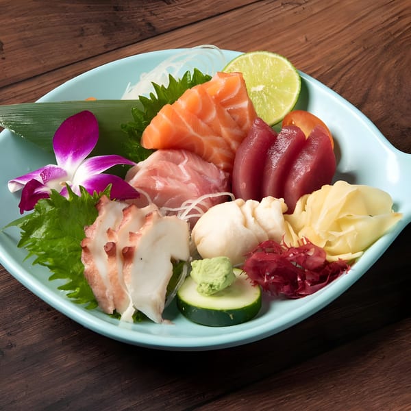 A vibrant sashimi platter with salmon, tuna, octopus, and scallops, garnished with a purple orchid.