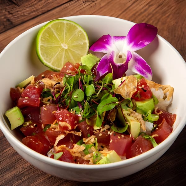 The Fish House's tuna poke bowl with avocado, microgreens, lime, and an orchid garnish.
